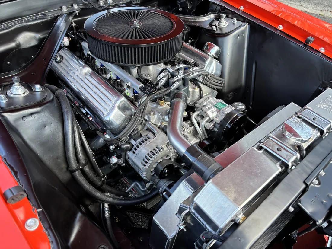 Fuel-injected V8 with accessory drive and pulley system installed in a red classic car